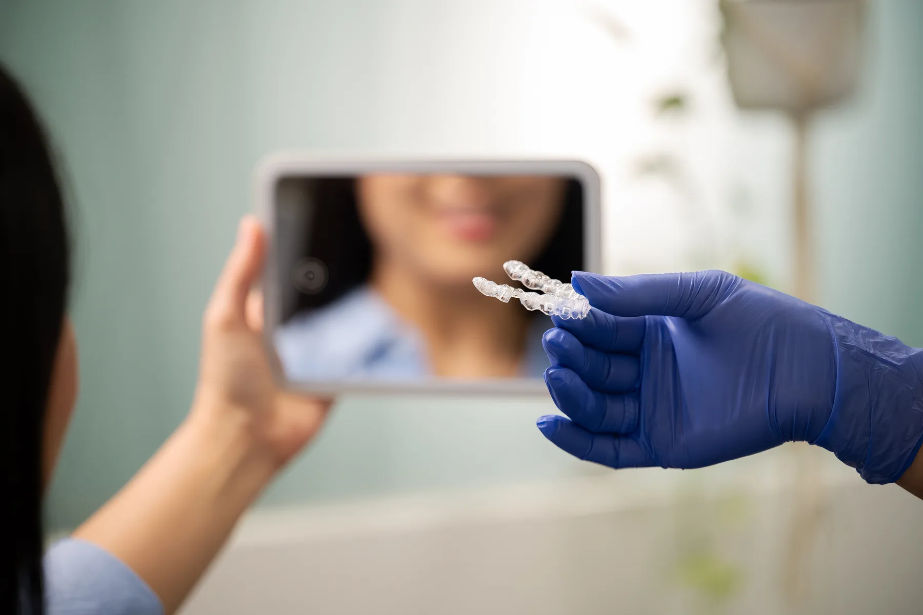 Patient checking Invisalign aligners in a mirror